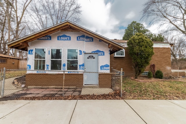 view of front of property featuring a fenced front yard and brick siding