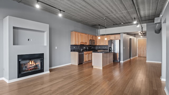 kitchen with stainless steel appliances, tasteful backsplash, dark wood finished floors, and rail lighting