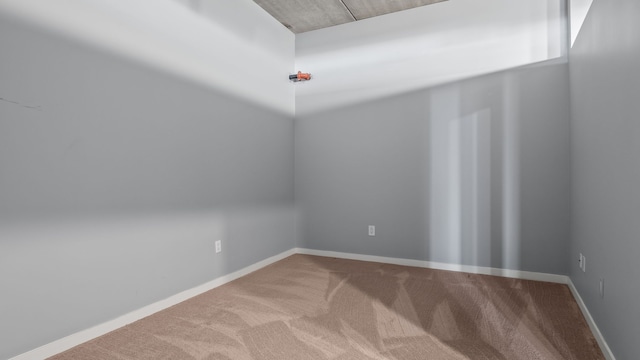 unfurnished room featuring carpet and baseboards