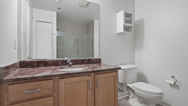 full bath with visible vents, tiled shower, vanity, and toilet