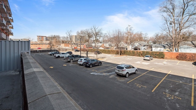 uncovered parking lot featuring fence