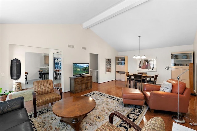 living area with high vaulted ceiling, visible vents, beam ceiling, and wood finished floors