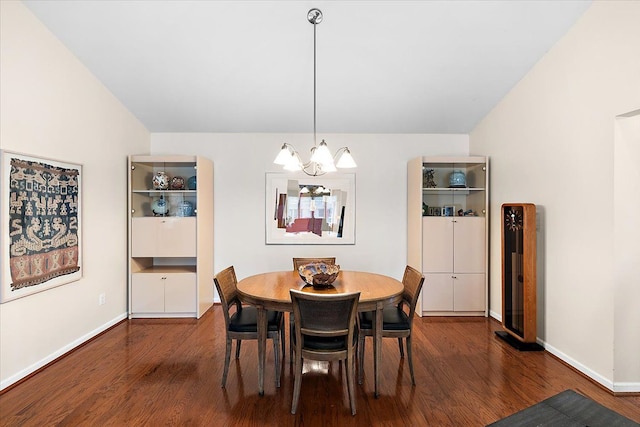 dining room featuring a chandelier, wood finished floors, and baseboards