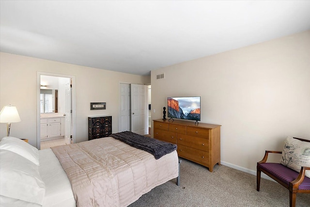 bedroom with ensuite bathroom, light carpet, visible vents, baseboards, and a closet