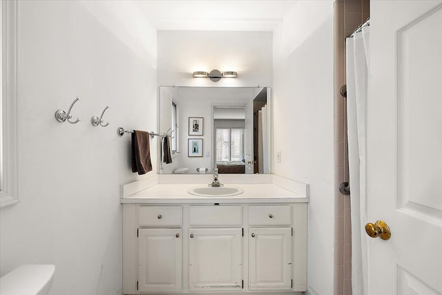 full bathroom featuring toilet, connected bathroom, and vanity