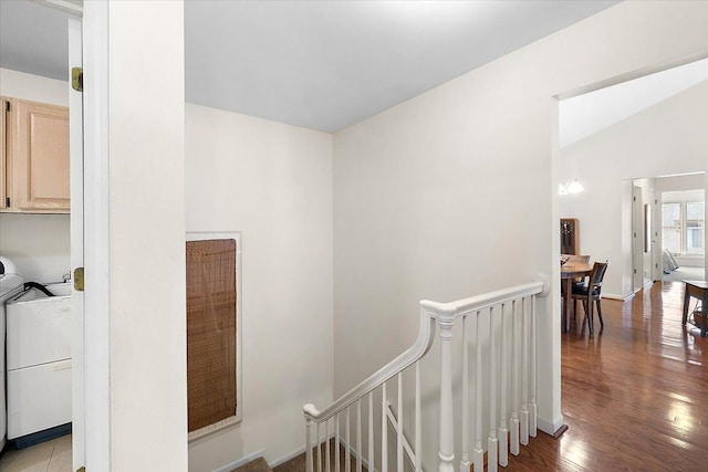 hallway featuring lofted ceiling, an upstairs landing, and wood finished floors