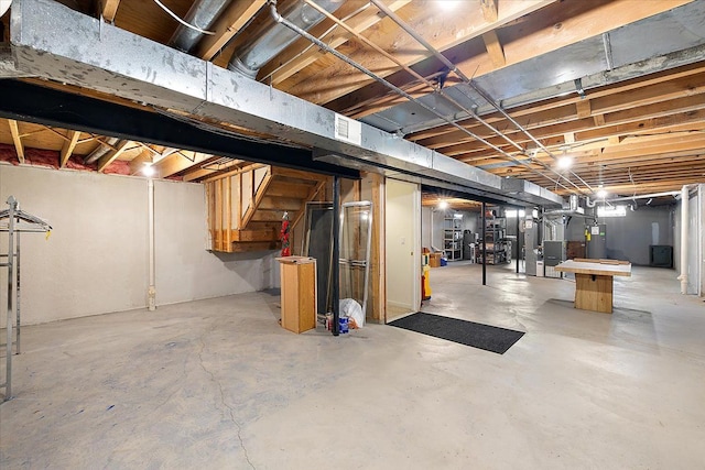 unfinished basement featuring heating unit, water heater, and visible vents