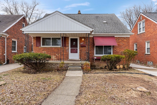 bungalow-style house featuring a shingled roof, a porch, and brick siding