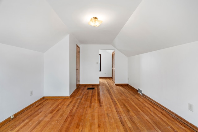 bonus room featuring vaulted ceiling, baseboards, visible vents, and light wood-style floors