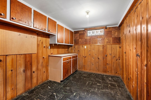 kitchen featuring dark floors, brown cabinets, and wooden walls