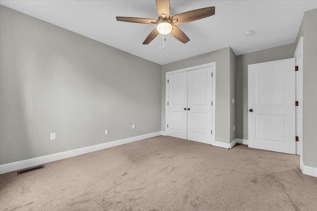 unfurnished bedroom with a ceiling fan, visible vents, baseboards, a closet, and carpet