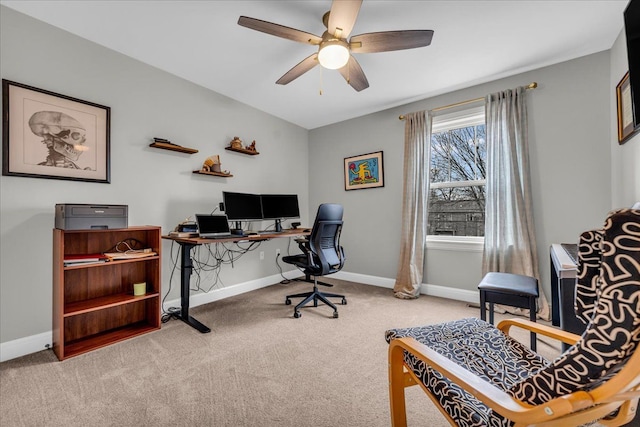 carpeted office with ceiling fan and baseboards