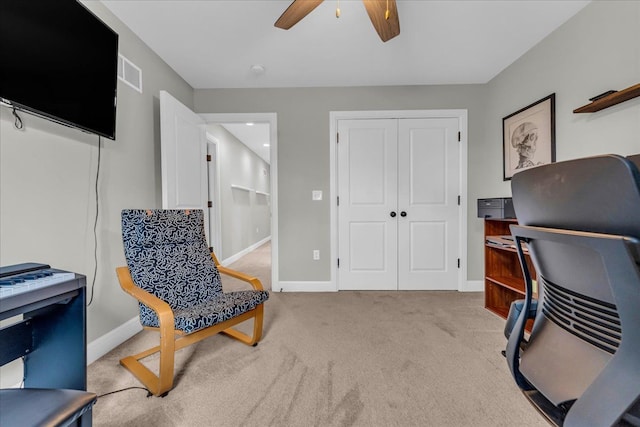 office area featuring light carpet, baseboards, visible vents, and a ceiling fan