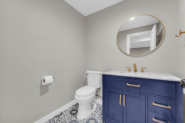 bathroom with baseboards, vanity, and toilet