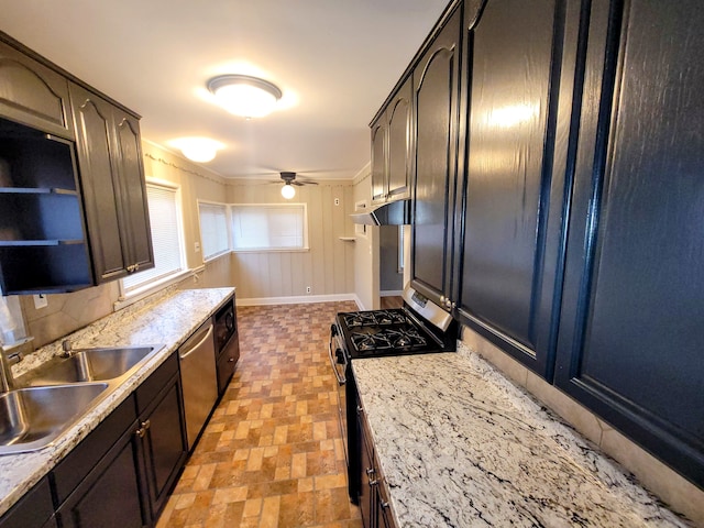 kitchen with ceiling fan, under cabinet range hood, a sink, appliances with stainless steel finishes, and stone finish floor