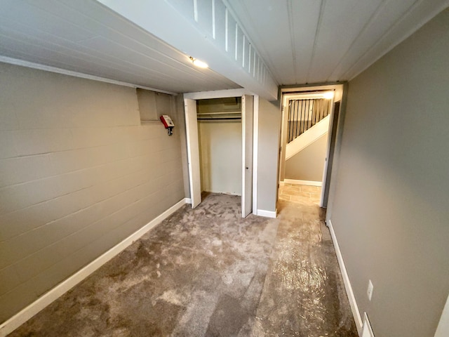 interior space with concrete block wall and baseboards