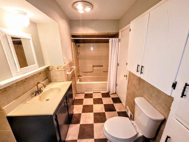 bathroom featuring tile walls, shower / bathtub combination with curtain, toilet, vanity, and tile patterned floors