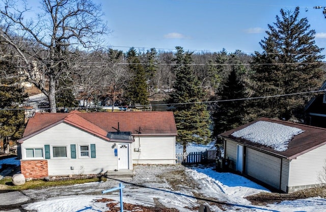 ranch-style home with a garage, an outbuilding, brick siding, and fence