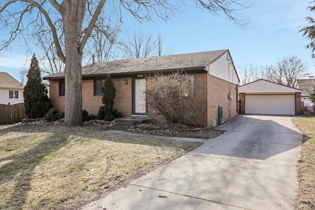 view of front facade with brick siding, an outdoor structure, a detached garage, and fence