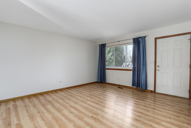 spare room with light wood finished floors and baseboards