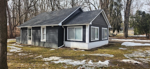 view of side of home featuring roof with shingles