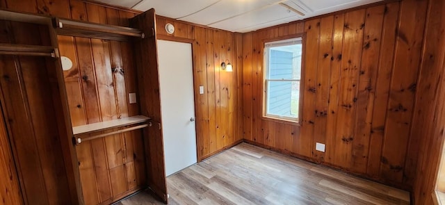 entryway with wooden walls and light wood-style floors