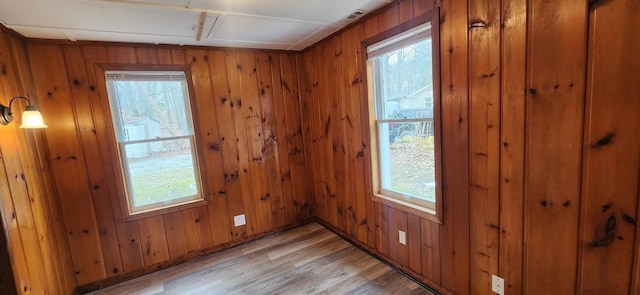 spare room featuring wood walls and light wood-style floors