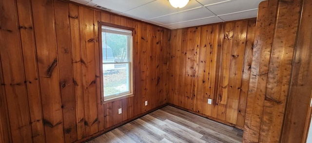 spare room with wood walls and light wood-style flooring