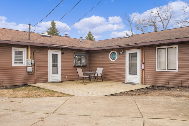 back of property featuring roof with shingles and a patio