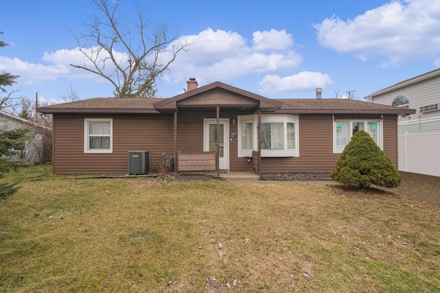 view of front of house featuring a front lawn, a chimney, and fence