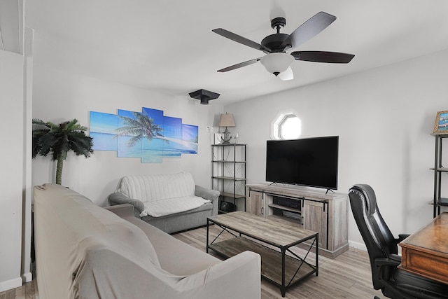 living area featuring ceiling fan, light wood-type flooring, and baseboards