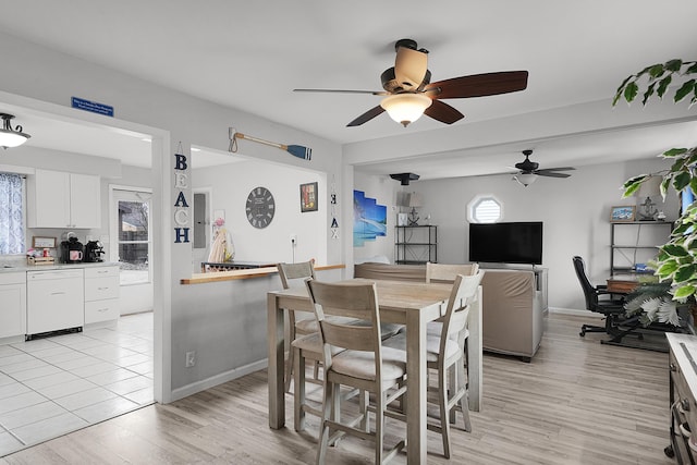 dining area featuring light wood-type flooring, baseboards, and a ceiling fan