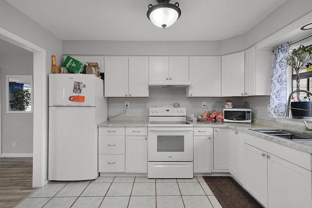 kitchen featuring white appliances, light countertops, a sink, and under cabinet range hood