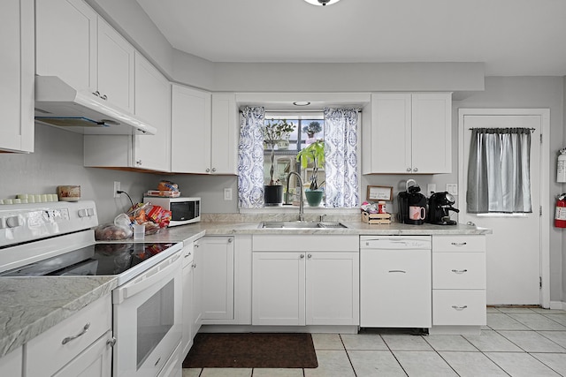 kitchen featuring white appliances, white cabinets, light countertops, under cabinet range hood, and a sink