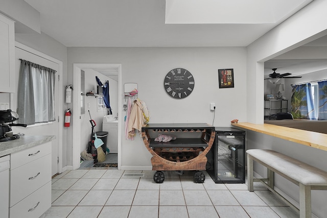 bathroom with washer / dryer, baseboards, a ceiling fan, wine cooler, and tile patterned flooring