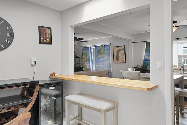 bar with ceiling fan, beverage cooler, and indoor bar