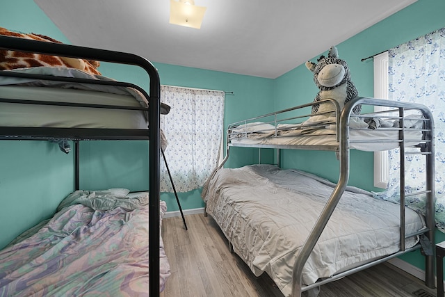 bedroom with baseboards and wood finished floors