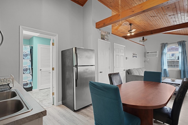 dining room featuring vaulted ceiling with beams, light wood finished floors, a wall mounted AC, a ceiling fan, and wooden ceiling