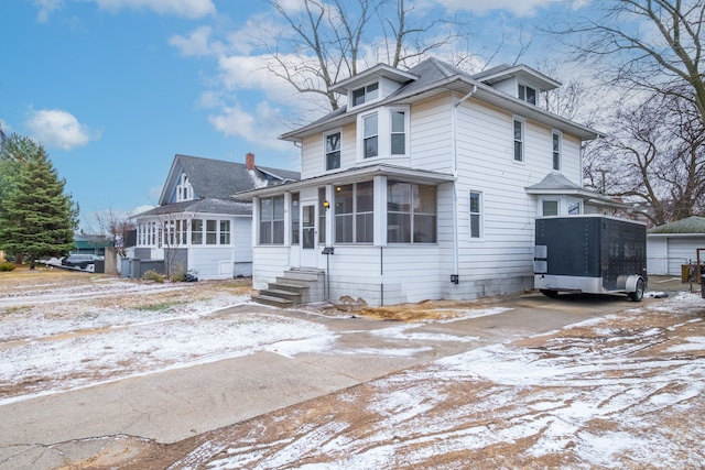 traditional style home with entry steps and a sunroom