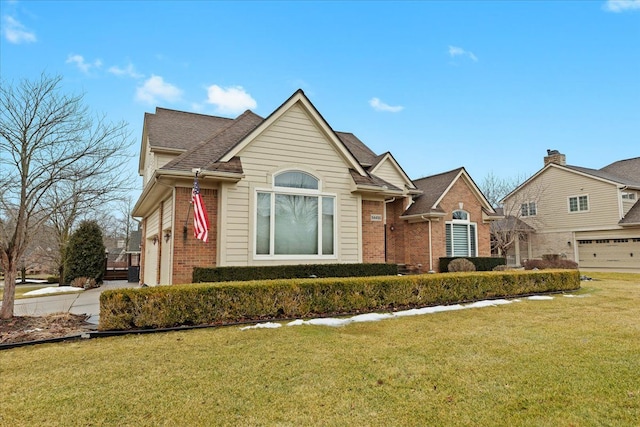 view of front of home with roof with shingles, a front lawn, and brick siding