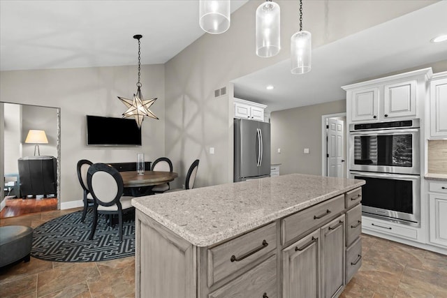 kitchen with visible vents, appliances with stainless steel finishes, stone finish floor, open floor plan, and a kitchen island