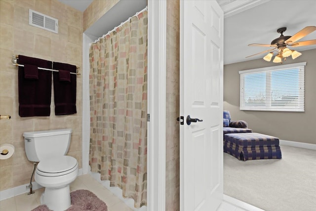 bathroom with visible vents, a shower with shower curtain, toilet, ceiling fan, and tile patterned floors