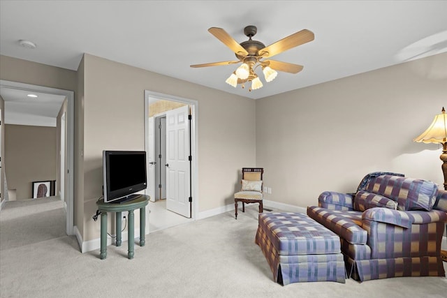 sitting room with carpet floors, baseboards, and a ceiling fan