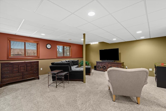 carpeted living area with a paneled ceiling and recessed lighting