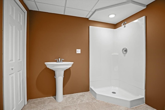 bathroom with a paneled ceiling, walk in shower, and tile patterned floors