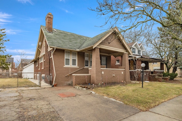 view of front of house featuring a front yard, a gate, brick siding, and fence