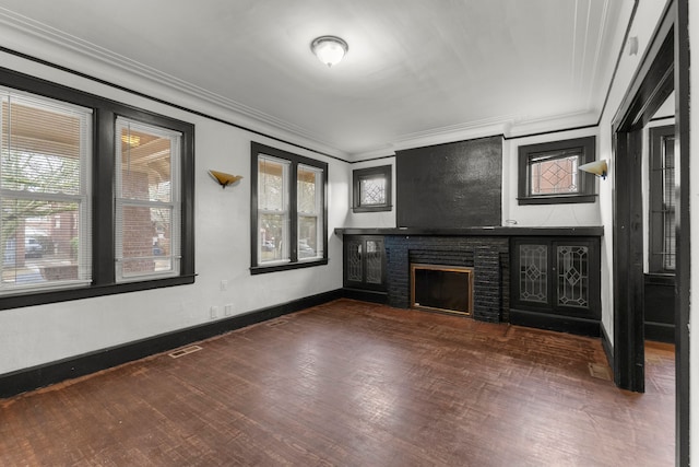 unfurnished living room featuring a brick fireplace, baseboards, visible vents, and crown molding