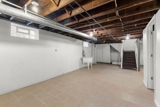 basement featuring stairs and a sink