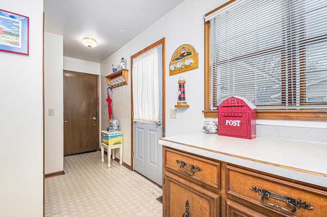 hallway featuring baseboards and light floors