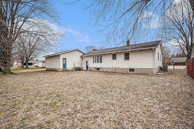 back of property featuring a chimney, fence, and central AC